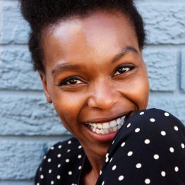 cheerful-african-woman-face-against-gray-wall-PNBJVQE